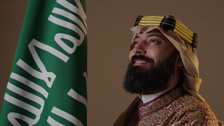 Saudi Man in Founding Day Attire with Saudi Flag