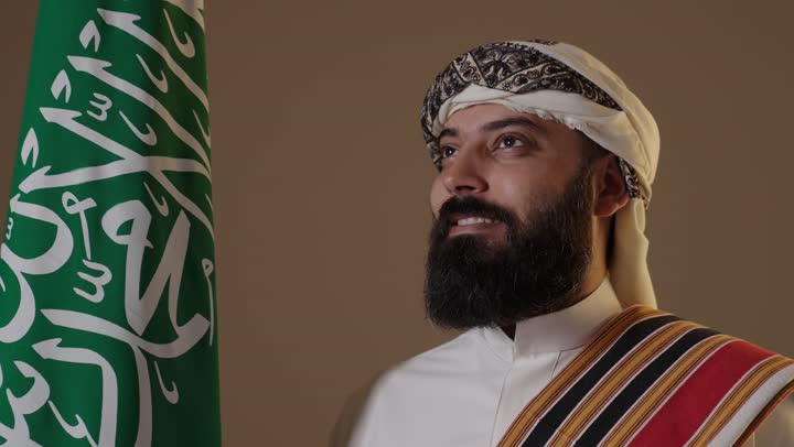 Saudi Man in Founding Day Attire with National Flag