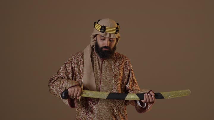 رجل سعودي بملابس يوم التأسيس التقليدية يحمل سيفاً