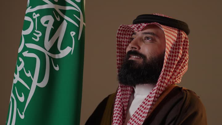 Saudi Man in Foundation Day Attire with Flag