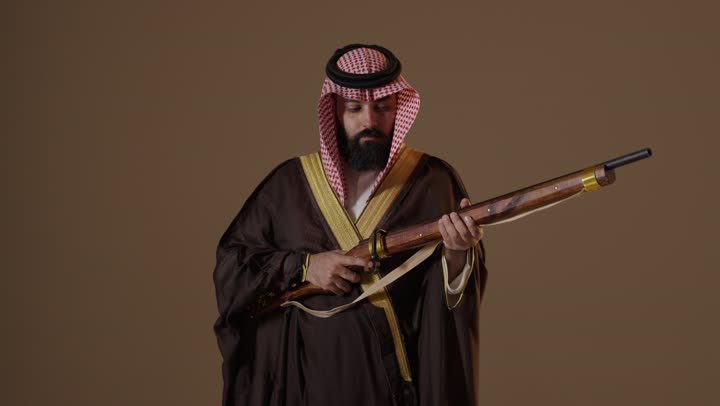 Saudi Man in Traditional Bisht Holding Vintage Rifle