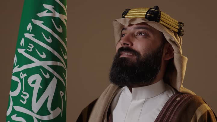 Saudi Man in Traditional Founding Day Attire with Flag