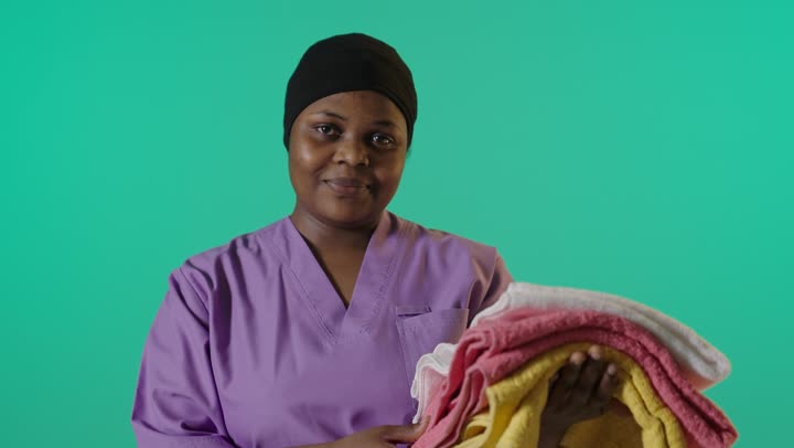 African Cleaner Holding Towels Green Screen Footage