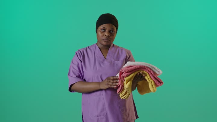 African Healthcare Worker Holding Towels Green Screen
