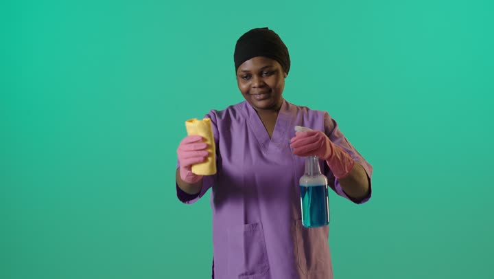 African Cleaner Holding Spray Bottle on Green Screen