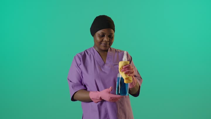 عاملة نظافة أفريقية خلفية خضراء علامة الإبهام