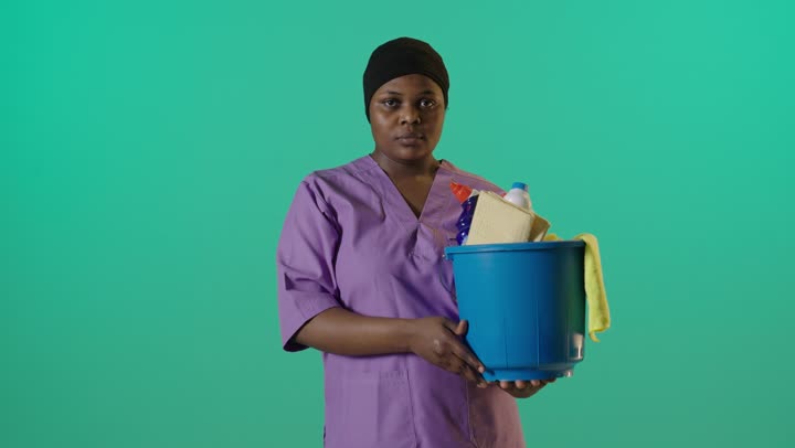 عاملة نظافة أفريقية إيماءة رفض خلفية خضراء