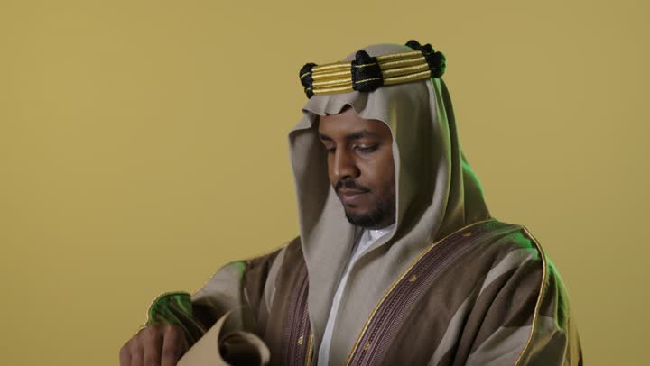 Saudi Man in Founding Day Attire Reading Scroll Studio