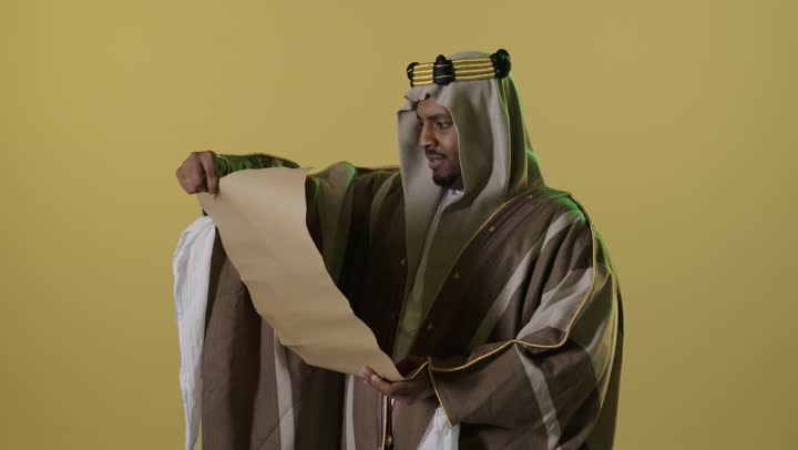 رجل سعودي بزي يوم التأسيس يقرأ مخطوطة قديمة
