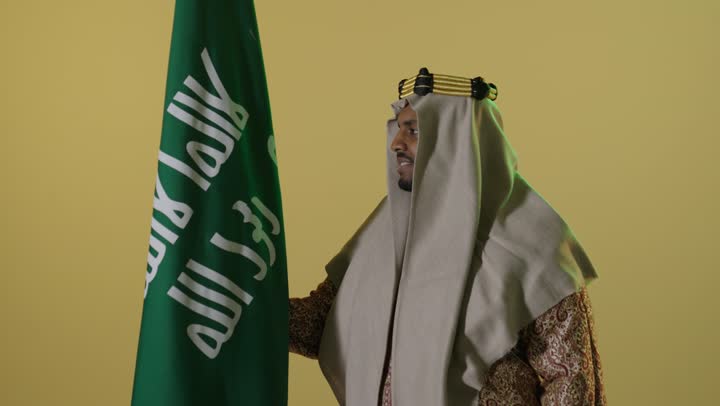 Saudi Man in Founding Day Attire with National Flag