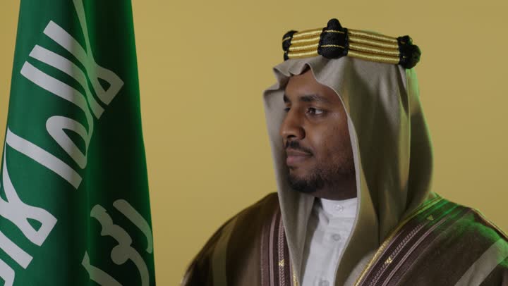 رجل سعودي بملابس يوم التأسيس مع العلم تصوير استوديو