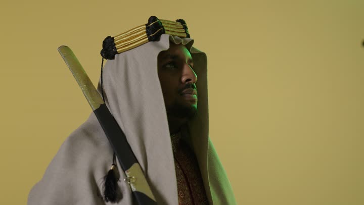 رجل سعودي بزي يوم التأسيس يحمل سيفاً تقليدياً