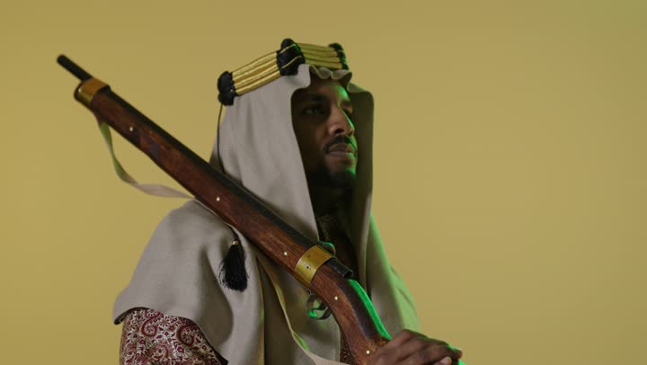 رجل سعودي بزي يوم التأسيس التقليدي مع بندقية قديمة