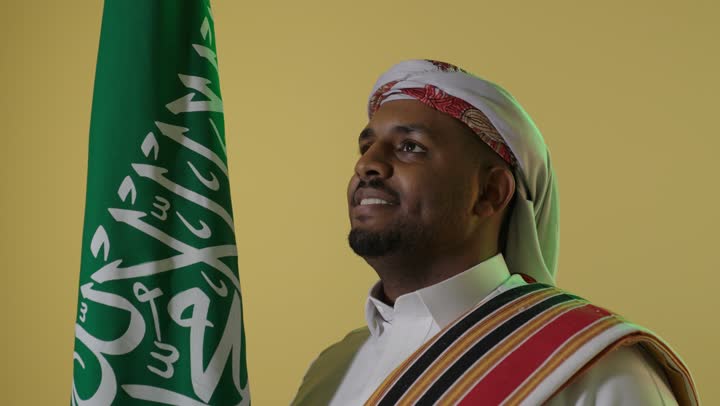 Saudi Man in Founding Day Attire with National Flag