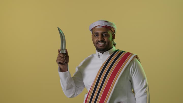 رجل سعودي بزي يوم التأسيس التقليدي يحمل خنجر تراثي