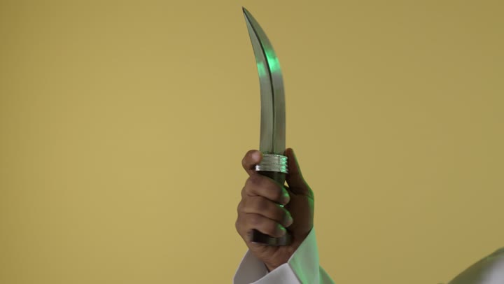 يد رجل سعودي تحمل خنجراً تراثياً تقليدياً