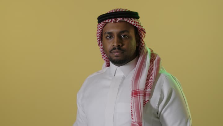 رجل سعودي بالزي التقليدي يبتسم خلفية صفراء فيديو