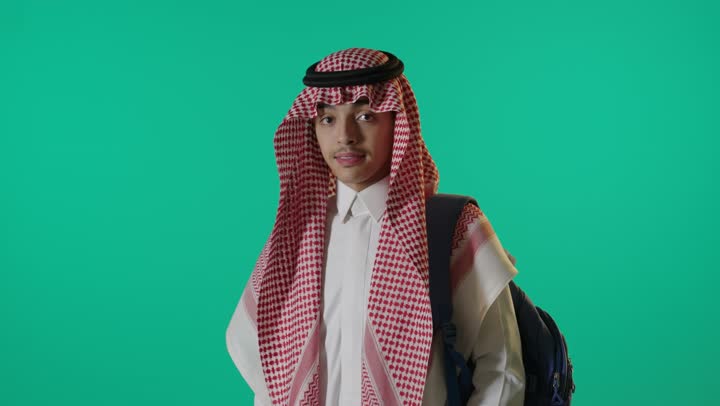 طالب سعودي يرتدي حقيبة ظهر على شاشة خضراء