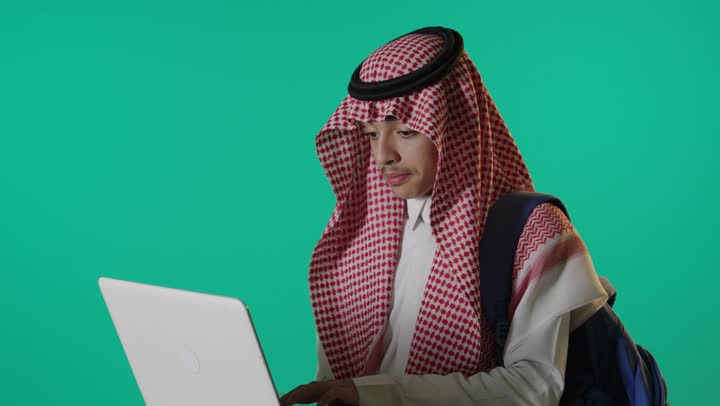 Saudi Male Student Using White Laptop on Green Screen