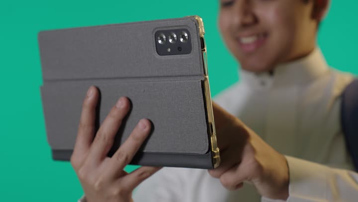 طالب سعودي يستخدم جهاز لوحي بخلفية شاشة خضراء