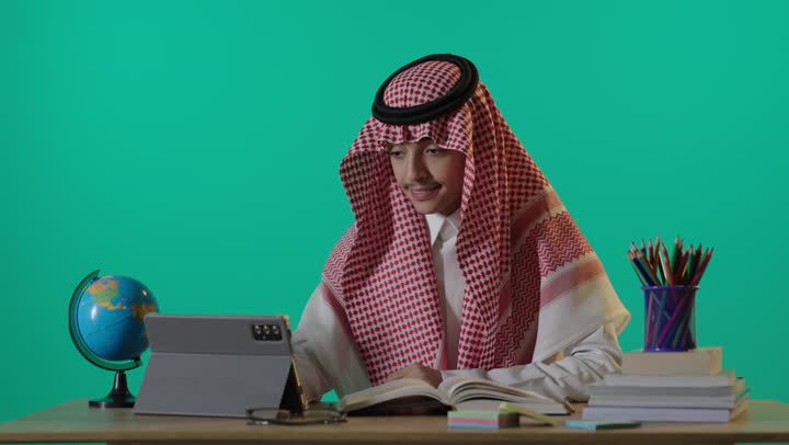 Saudi Student Writing at Desk Green Screen Footage