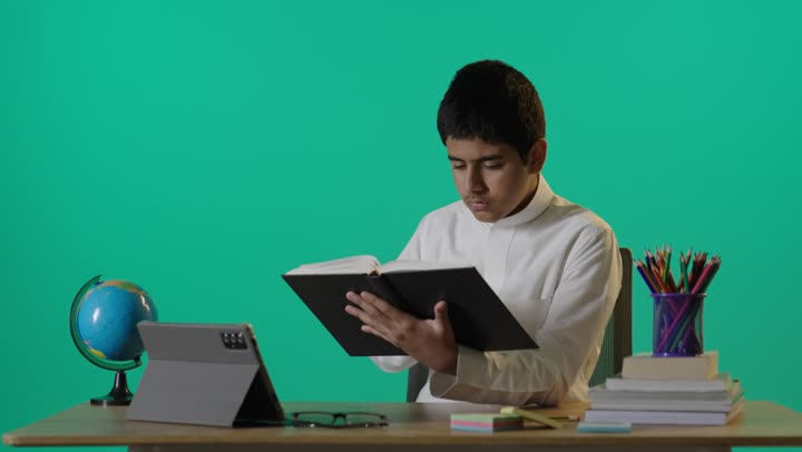 Saudi Schoolboy Studying and Yawning on Green Screen