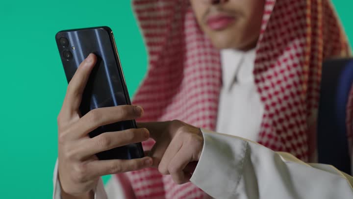 Saudi Man Using Smartphone on Green Screen Background