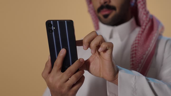 Saudi Man Using Smartphone in Traditional Dress Studio Clip