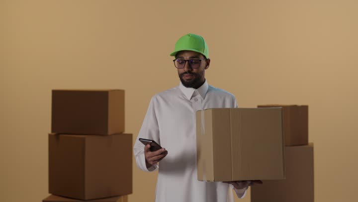Saudi Courier Holding Delivery Box and Talking on Phone