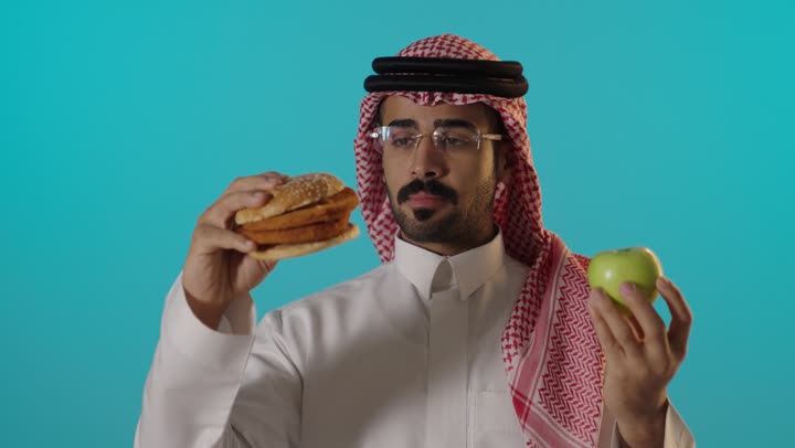 رجل سعودي يختار بين البرجر والتفاحة الخضراء