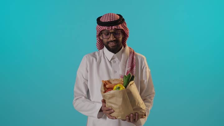 رجل سعودي يمسك بحقيبة خضروات طازجة