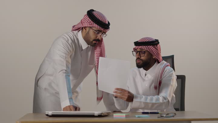 رجال أعمال سعوديون يناقشون وثيقة في المكتب