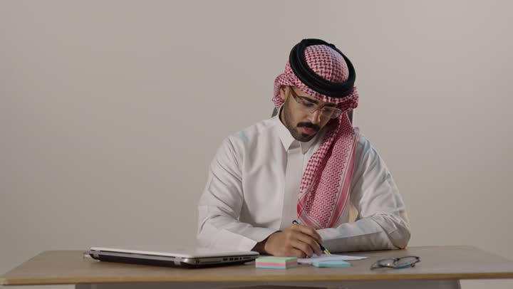رجل أعمال سعودي يفكر على مكتب العمل