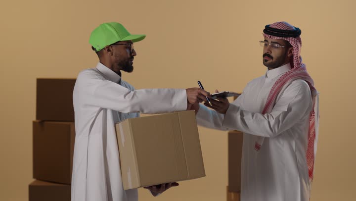 عامل توصيل سعودي يسلم طرداً لرجل أعمال بالزي التقليدي