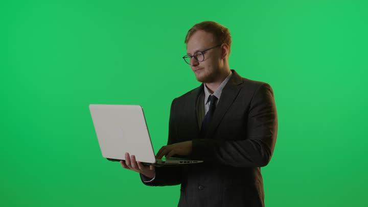 رجل أعمال يستخدم الكمبيوتر المحمول بخلفية كروما خضراء