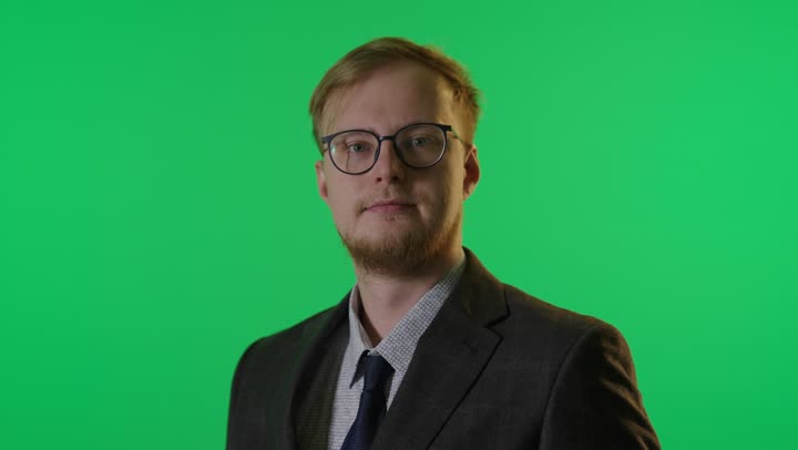 رجل أعمال بالبدلة الرسمية أمام كروما خضراء