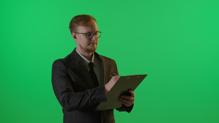 رجل أعمال يكتب على لوحة ملاحظات شاشة خضراء