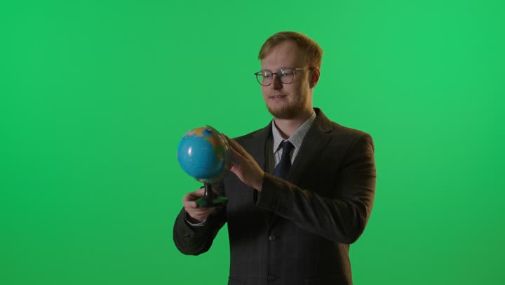 رجل أعمال يدير الكرة الأرضية على كروما خضراء