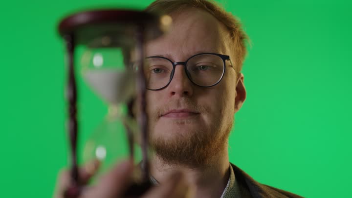 رجل مع ساعة رملية على خلفية خضراء كروما