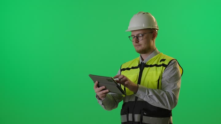 مهندس يرتدي سترة السلامة يستخدم تابلت على كروما