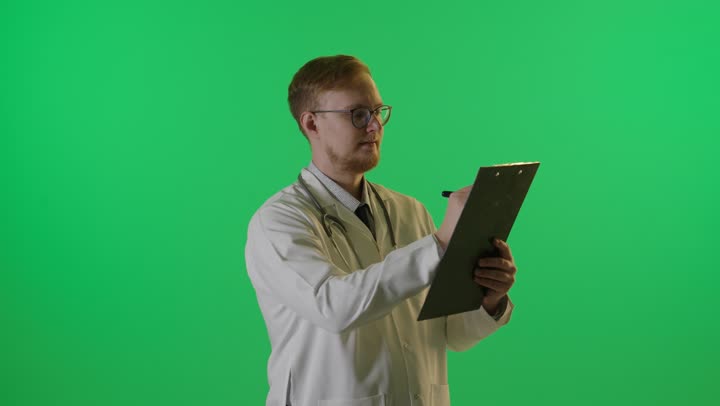 طبيب يكتب على لوحة ملاحظات كروما خضراء