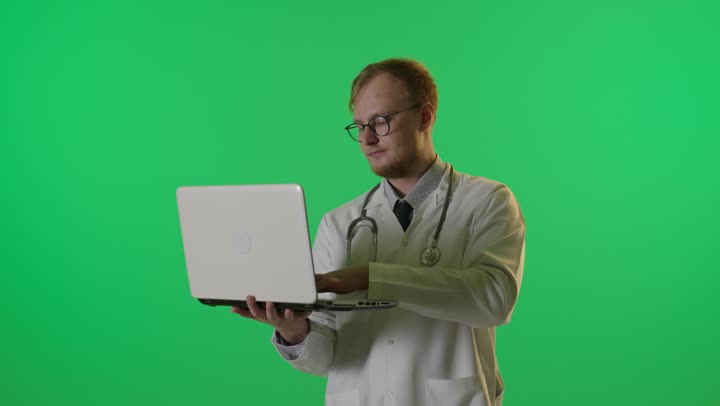 طبيب يكتب على كمبيوتر محمول كروما خضراء