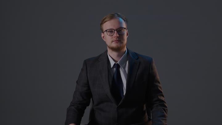 رجل أعمال يقوم بإيماءة الإبهام للأسفل في الاستوديو