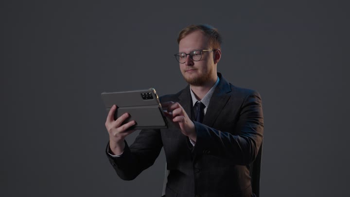 رجل أعمال يستخدم جهاز لوحي في الاستوديو