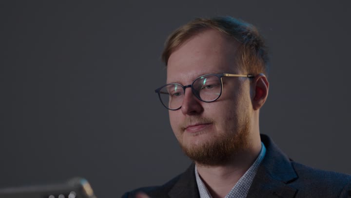 رجل أعمال يستخدم جهازاً لوحياً في استوديو احترافي