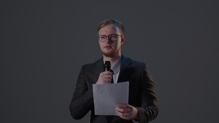 رجل أعمال يتحدث في الميكروفون داخل الاستوديو