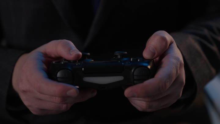 لقطة مقربة ليدين تمسكان بجهاز تحكم ألعاب