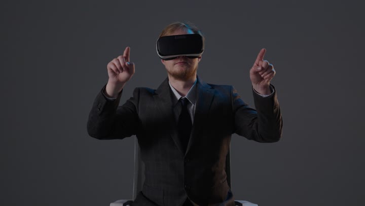 Businessman Wearing VR Headset Gesturing in Studio