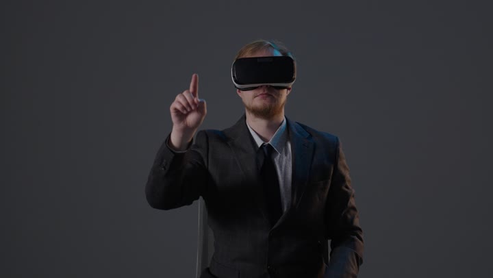 رجل أعمال يرتدي نظارة واقع افتراضي يتفاعل مع واجهة افتراضية