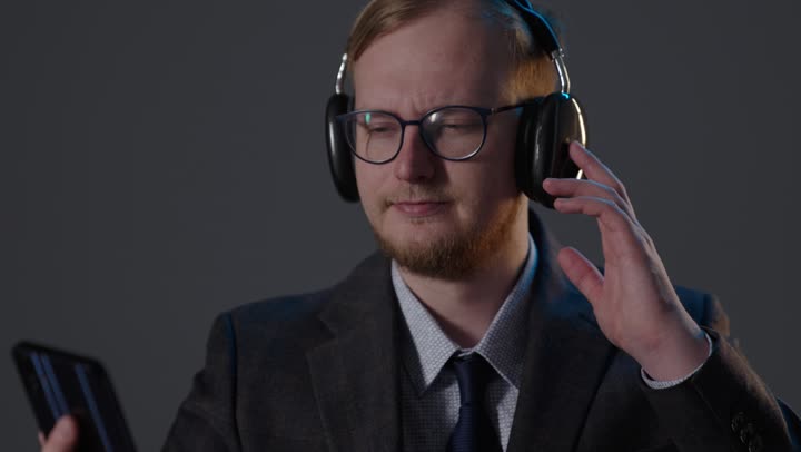 Businessman with Headphones and Smartphone Studio Footage